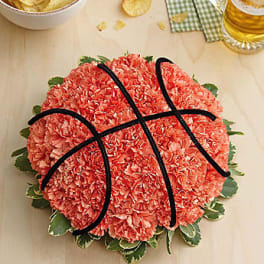 Basketball-shaped arrangement of coral carnations with black piping
