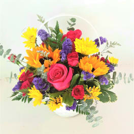 Basket arrangement of pink roses, yellow daisies, and purple flowers