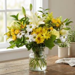 Yellow and white mixed bouquet in a clear glass vase