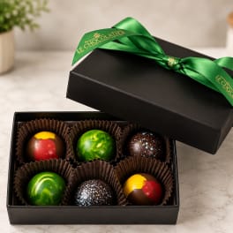 Box of assorted chocolates with a green ribbon on the lid