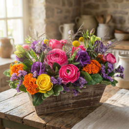Colorful mixed flower arrangement in a rustic wooden box