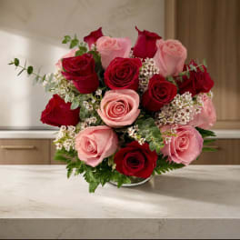 Bouquet of red and pink roses in a low vase