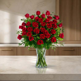 Red roses arranged in a clear glass vase
