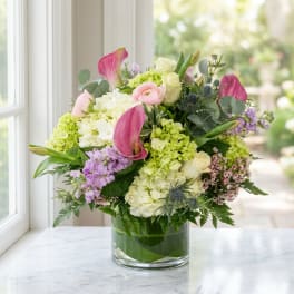 Mixed pastel flower arrangement in a clear glass vase