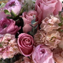 Pink roses and pale peach flowers in a close-up bouquet