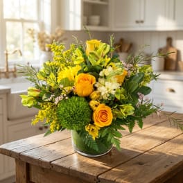 Yellow and orange flower arrangement in a clear glass vase
