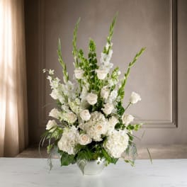 White floral arrangement in a white bowl vase