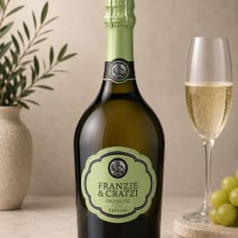 Bottle of prosecco beside a filled champagne flute and grapes