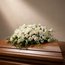 White rose arrangement on a wooden casket