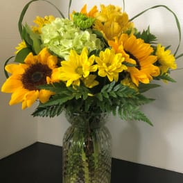 Sunflower and yellow mixed bouquet in a clear glass vase