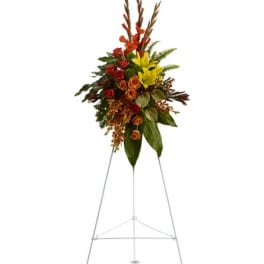 Standing floral spray with red, orange, and yellow blooms on an easel