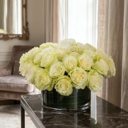 Cream roses arranged in a low glass vase