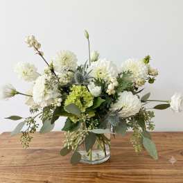 White and green floral arrangement in a clear glass vase