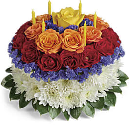 Round bouquet of red and orange roses with white chrysanthemums and candles