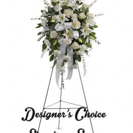 White standing floral spray on a metal easel with ribbon