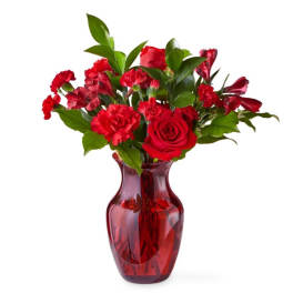 Red roses and carnations in a red glass vase