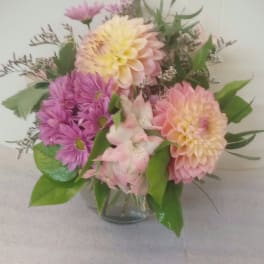 Mixed pink and peach flowers in a clear glass vase