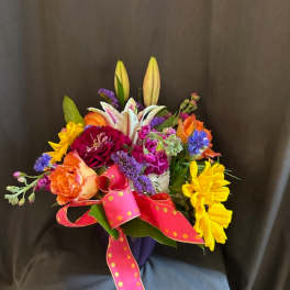 Colorful bouquet with lilies, roses, and a pink polka-dot ribbon