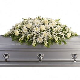 White floral casket spray on a gray casket