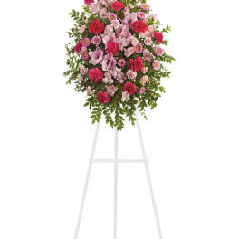 Standing floral spray of pink and red flowers on a white easel