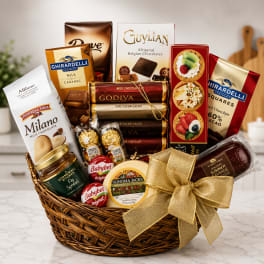 Gift basket filled with chocolates, cookies, cheese, and sausage, tied with a gold bow