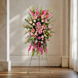 Tall pink floral standing arrangement on an easel