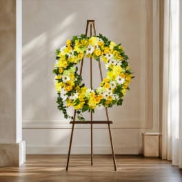 Yellow and white floral wreath on a wooden easel