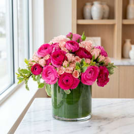 Pink and blush roses arranged in a clear glass vase
