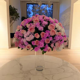 Large pink and white floral arrangement in a clear glass vase