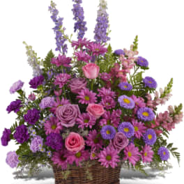 Basket arrangement of pink and purple flowers with roses and daisies