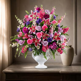 Large bouquet of pink, purple, and white flowers in a white vase