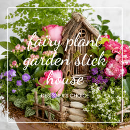 Garden-style floral arrangement with pink roses and purple blooms around a small twig house