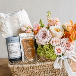 Flower gift basket with roses, hydrangeas, tea, and dried orange slices