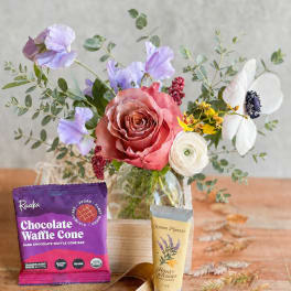 Bouquet in a glass vase with a chocolate bar and hand cream