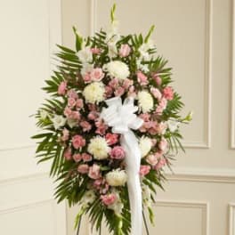 Standing floral spray with pink and white flowers and a white ribbon