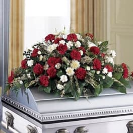 Red and white floral casket spray on a silver casket