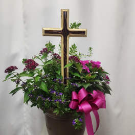 Potted floral arrangement with a wooden cross and pink ribbon