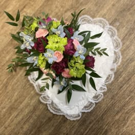 Bouquet of pink, burgundy, and lime flowers on white lace fabric