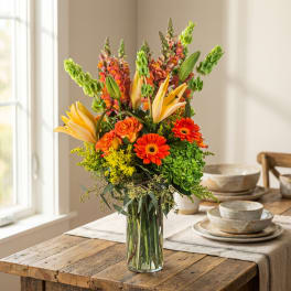 Bouquet of orange and yellow flowers in a clear glass vase