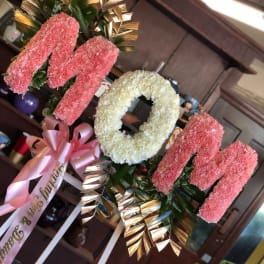 Pink and white floral standing arrangement with a ribbon bow