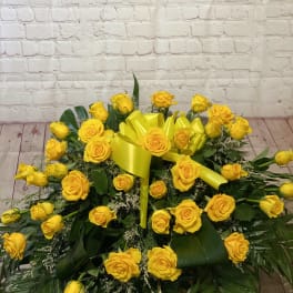 Large yellow rose arrangement with a bright yellow ribbon