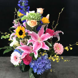 Colorful mixed flower arrangement in a clear glass vase