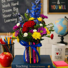 Colorful bouquet in a pencil holder with a blue ribbon