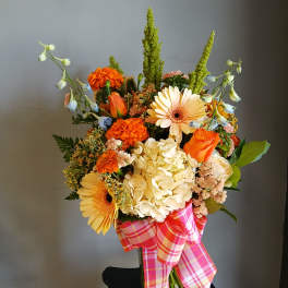 Mixed bouquet with orange and cream flowers in a glass vase