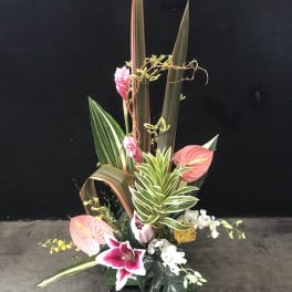 Tall tropical floral arrangement with pink anthuriums and orchids