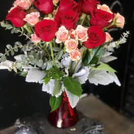 Red and pink roses arranged in a red vase