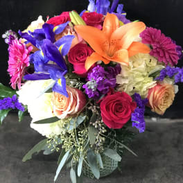 Colorful bouquet with roses, lilies, irises, and chrysanthemums in a vase