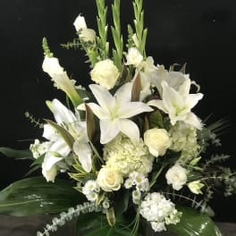 White floral arrangement with lilies, roses, and hydrangeas