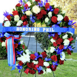 Large floral wreath with red, white, and blue flowers on an easel