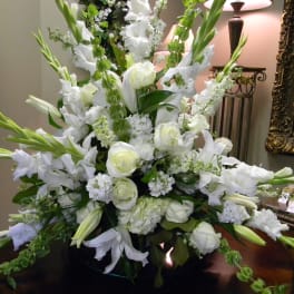 Large white floral arrangement with roses and lilies in a vase